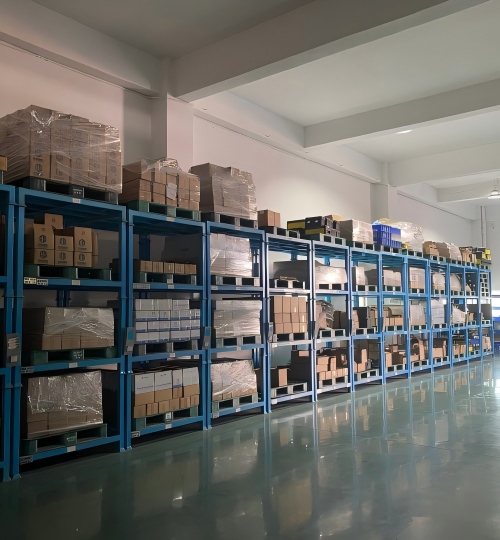 Custom metal components neatly packaged in boxes and systematically stored on racks at Rilon for efficient inventory management.