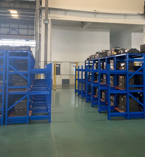 Metal molds stored and organized on blue racks after custom part production at Rilon.