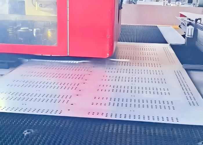 Servo-controlled CNC turret punching machine processing precision perforated sheet metal components.tal