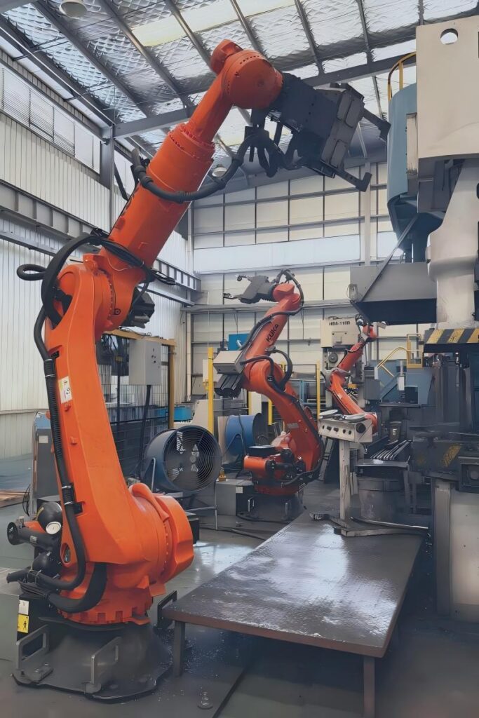 Industrial robot arm handling high-strength custom metal parts on an automated forging production line, ensuring extreme durability and manufacturing consistency for Tier 1 industrial applications.